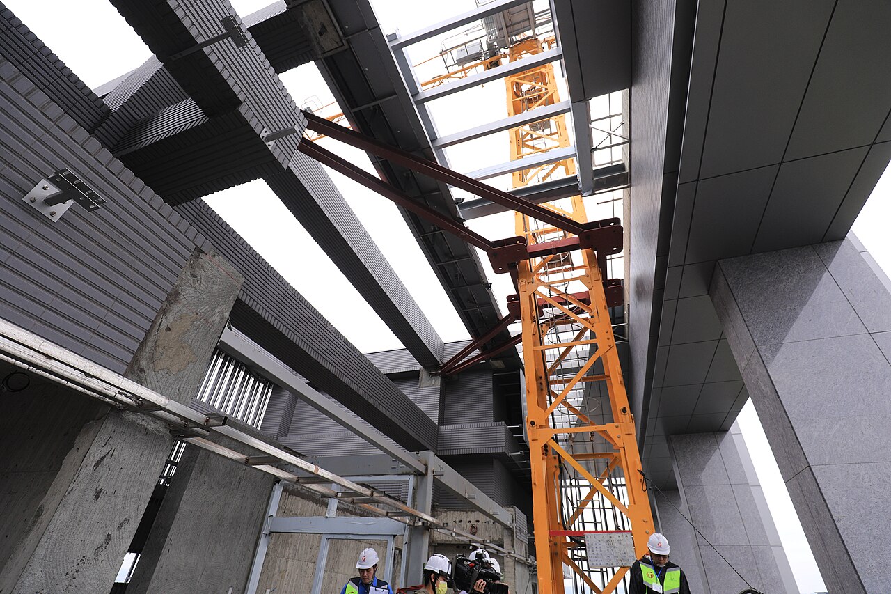 Active building construction site with tower crane and workers